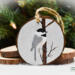 A handmade bird Christmas ornament with a hand-painted Carolina chickadee in the snow on a wood slice at Cove Creek Photography.